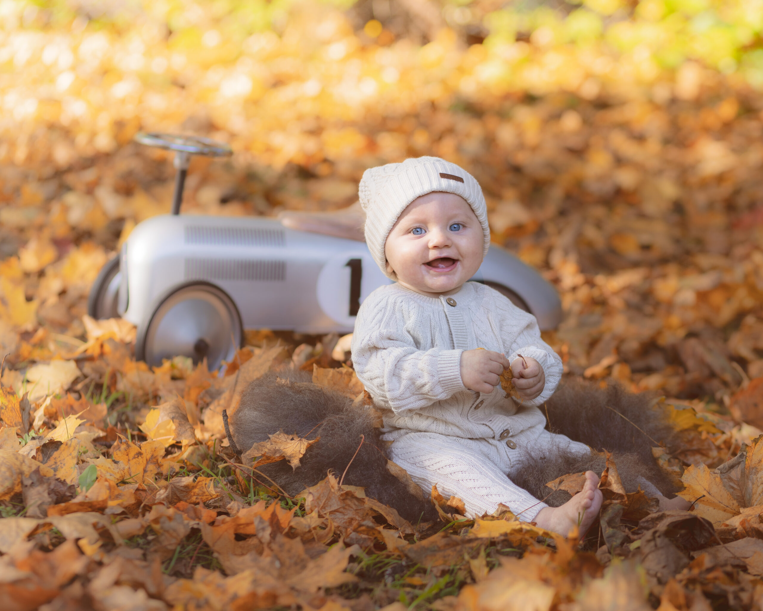 høstbilder av baby som smiler i løv