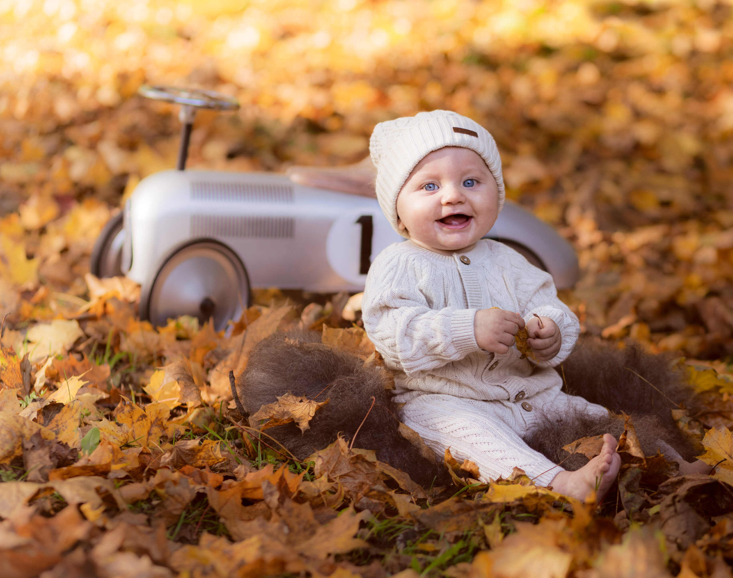 babyfotografering, baby sitter i høstløv og ler