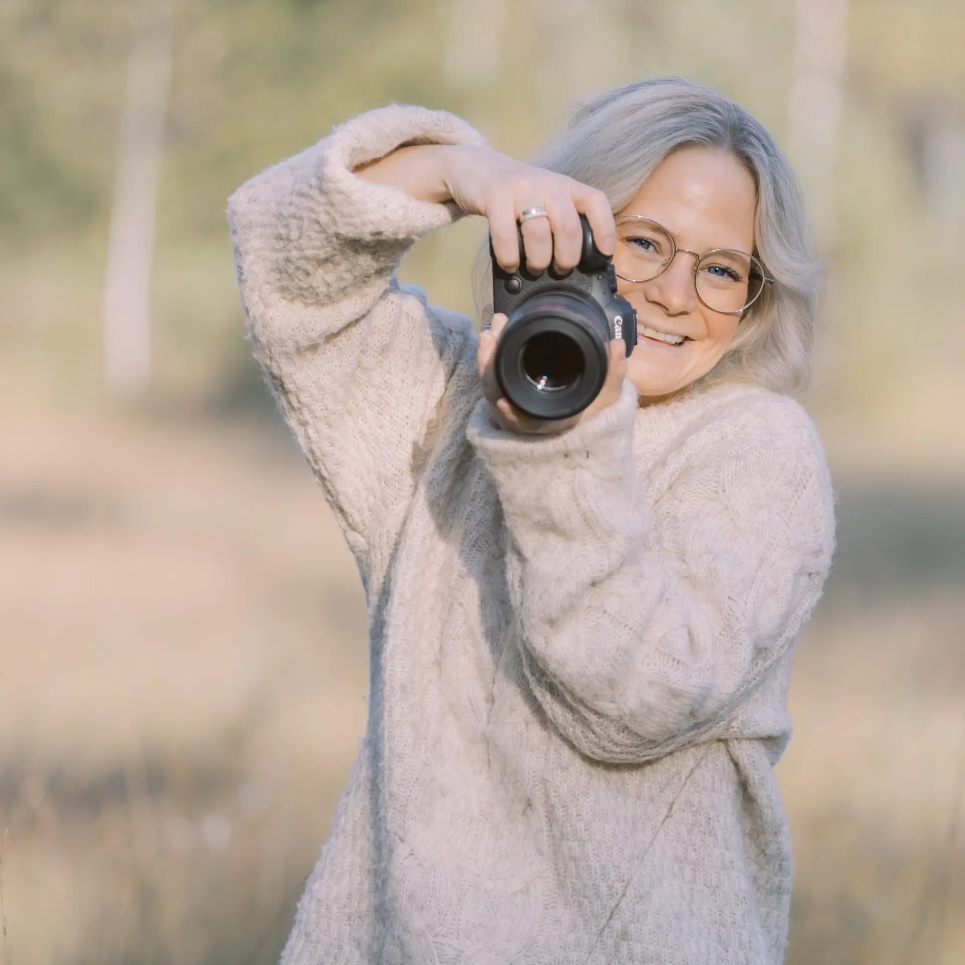 selvportett av fotografen som holder et kamera og smiler